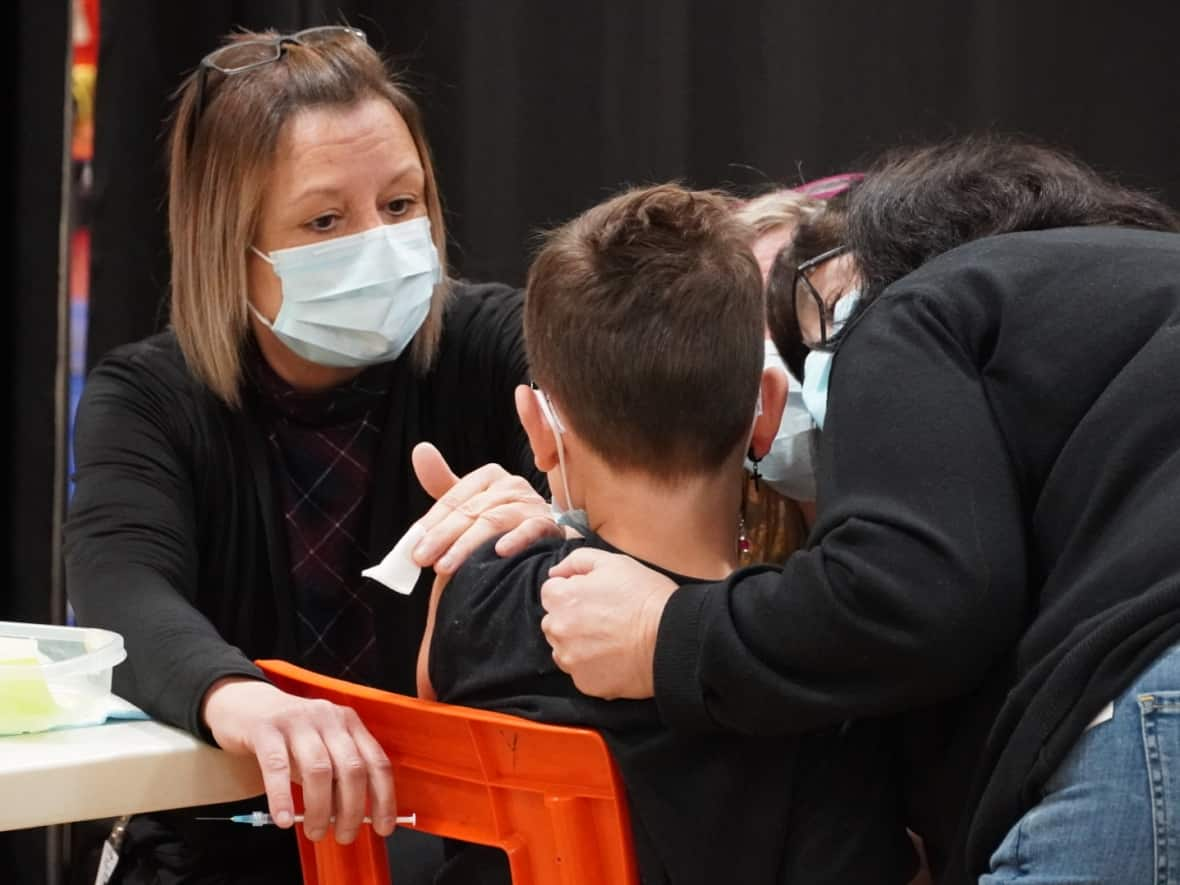 A nurse administers the first dose of the pediatric COVID-19 vaccine to a child at École des Belles-Rives in Gatineau, Que., on Monday. (Jacques Corriveau/CBC - image credit)