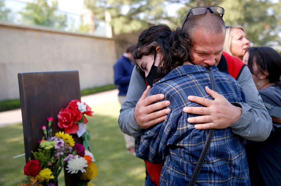 Mickey Paul Maroney hugs Little Axe elementary student Emelia Bush after she placed flowers on the chair of his father, Mickey B. Maroney, at the Oklahoma City National Memorial & Museum in Oklahoma City on Tuesday.