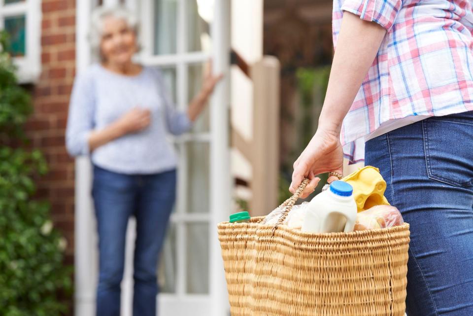 Persona lleva la compra a otra persona hasta su casa. 