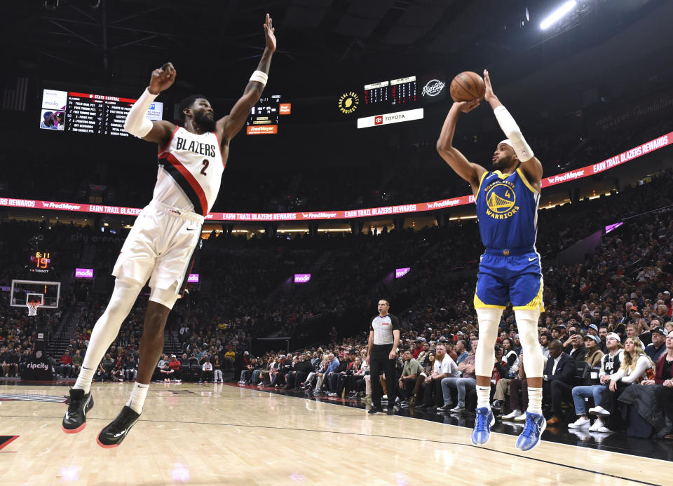 Golden State Warriors guard Moses Moody, right, shoots the ball over Portland Trail Blazers center Deandre Ayton, left, during the first half of an NBA basketball game in Portland, Ore., Thursday, April 11, 2024. (AP Photo/Steve Dykes)