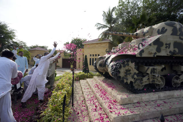 People spread flowers on army tank during a rally to show solidarity with Pakistan's army in Karachi, Pakistan, Friday, May 19, 2023. (AP Photo/Fareed Khan)