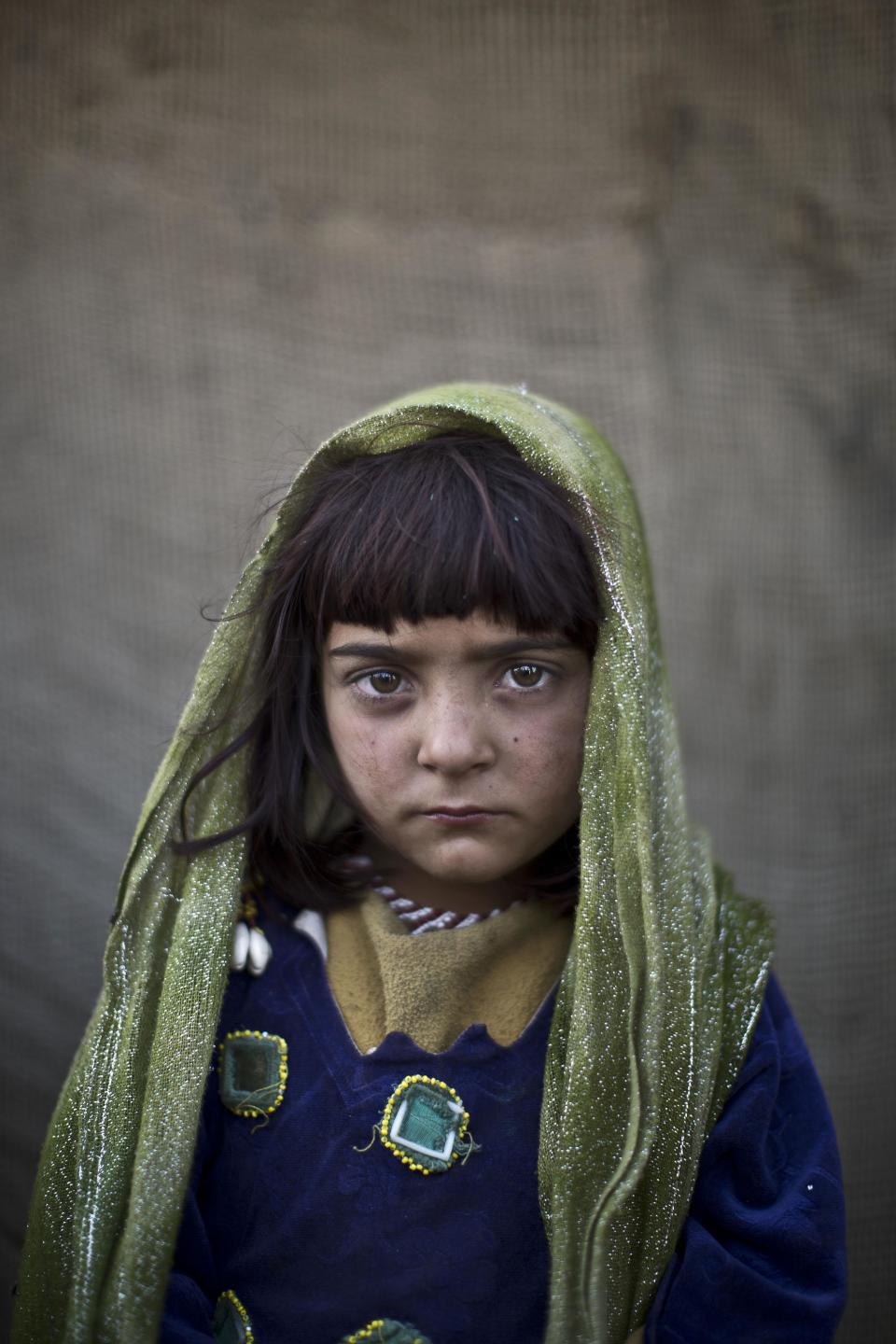 In this Saturday, Jan. 25, 2014 photo, Afghan refugee girl, Zarlakhta Nawab, 6, poses for a picture, while playing with other children in a slum on the outskirts of Islamabad, Pakistan. For more than three decades, Pakistan has been home to one of the world’s largest refugee communities: hundreds of thousands of Afghans who have fled the repeated wars and fighting their country has undergone. Since the 2002 U.S.-led invasion of Afghanistan, some 3.8 million Afghans have returned to their home country, according to the U.N.’s refugee agency. (AP Photo/Muhammed Muheisen)