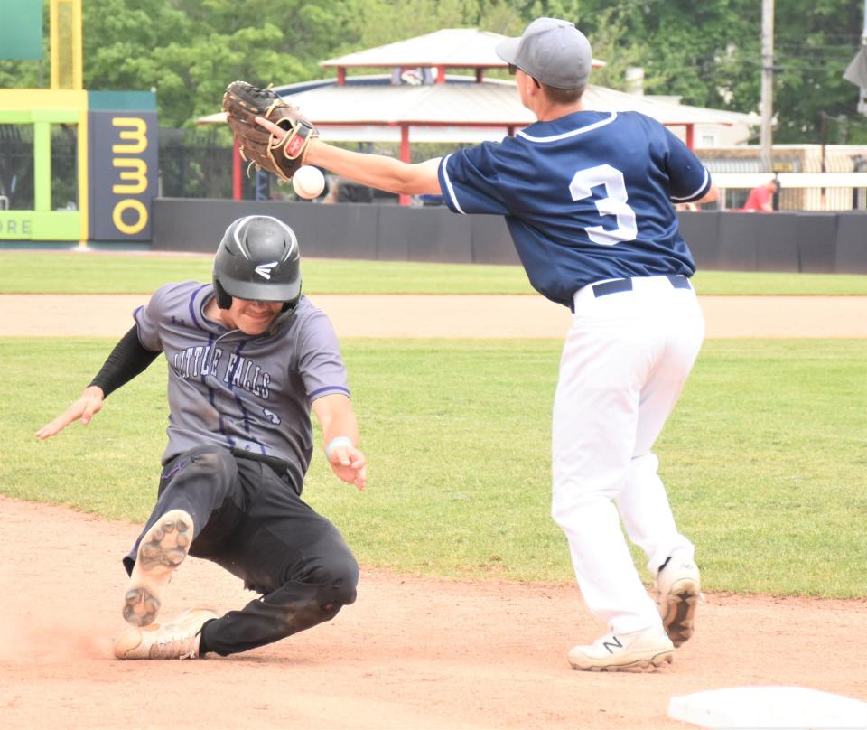 Little Falls Mountie Chase Regan (left) slides into third base and the throw from the outfield gets by third baseman Mike Hines (3) of the Schuyler Storm Saturday in a Class C regional baseball playoff game at Mirabito Stadium.