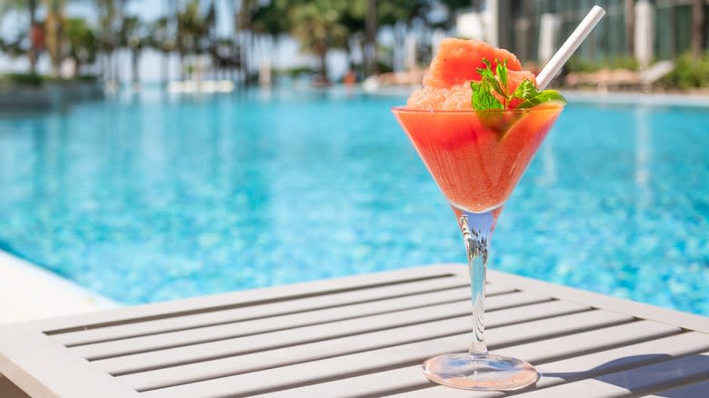 A frozen red cocktail by a pool