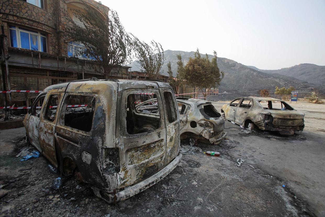 Burnt vehicles are pictured in the aftermath of a wildfire in Bejaia, Algeria (REUTERS)