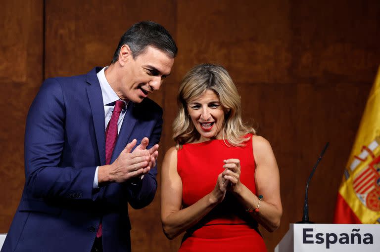 El presidente del Gobierno en funciones y secretario general del Partido Socialista, Pedro Sánchez, y la ministra de Trabajo en funciones y fundadora de la alianza de partidos de extrema izquierda Sumar, Yolanda Díaz, aplauden tras firmar un acuerdo para formar un gobierno de coalición en Madrid