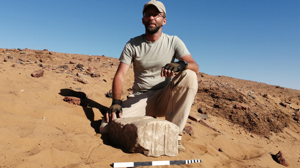 Dawid Wieczorek sits with one of the blocks from the temple.