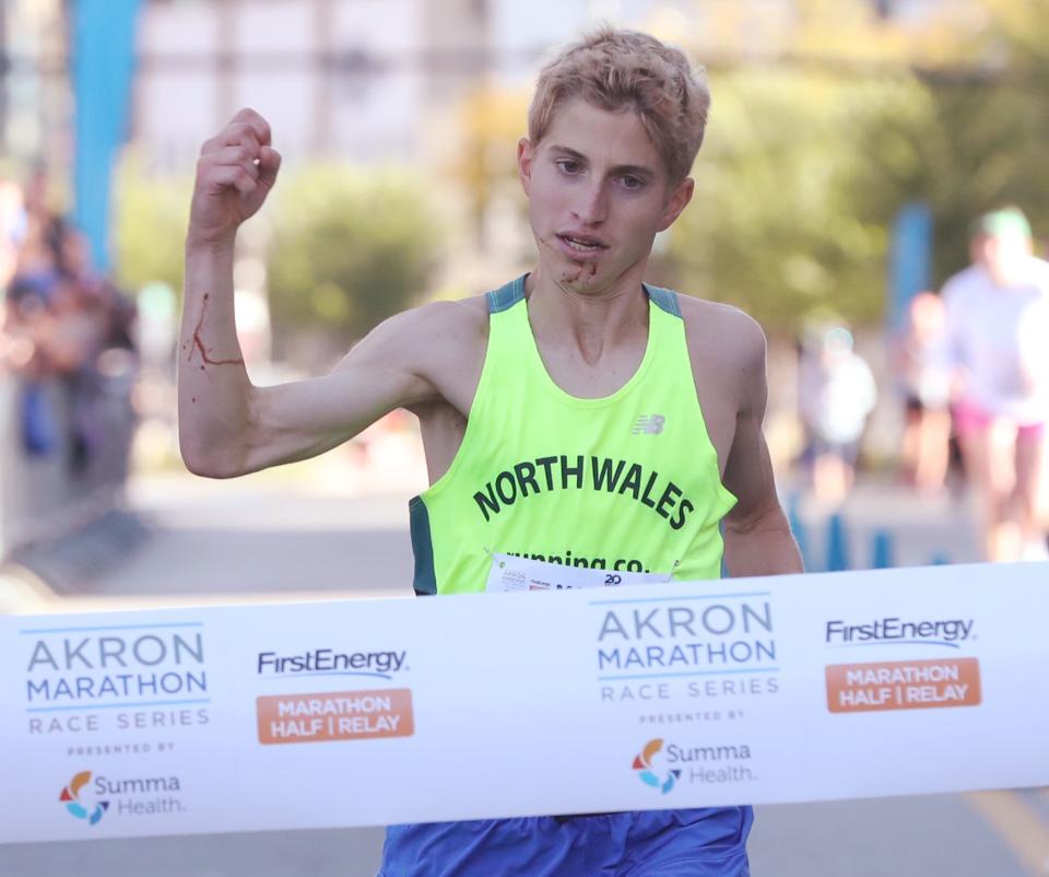 Zachary Hoagland hits the finish line to win the full marathon at the 20th Akron Marathon.