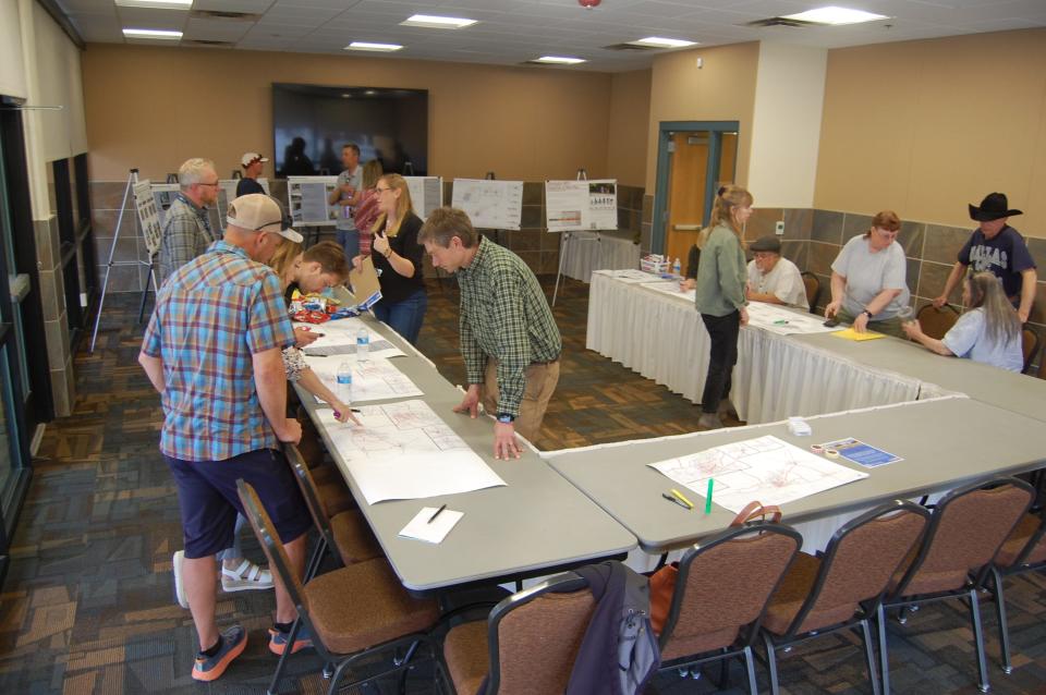 Local residents attending a meeting at the Farmington Civic Center on April 12 examine a series of displays outlining possible alternatives for bicycle and pedestrian infrastructure changes throughout San Juan County.