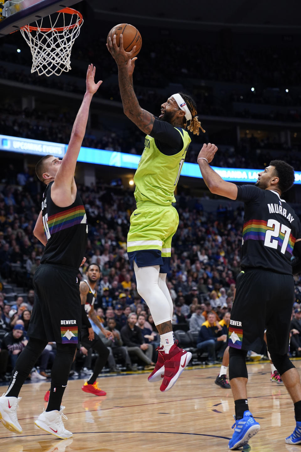 Minnesota Timberwolves forward James Johnson, center, goes up to shoot against Denver Nuggets center Nikola Jokic (15) and Jamal Murray (27) during the second quarter of an NBA basketball game Sunday, Feb. 23, 2020, in Denver (AP Photo/Jack Dempsey)