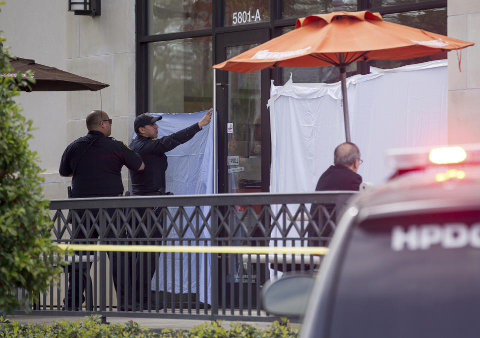 Houston Police officers investigate the scene of a fatal shooting at a Dunkin' Donuts on the 5800 block of Memorial Drive Friday, Feb. 15, 2019, in Houston. (Godofredo A. Vasquez/Houston Chronicle via AP)