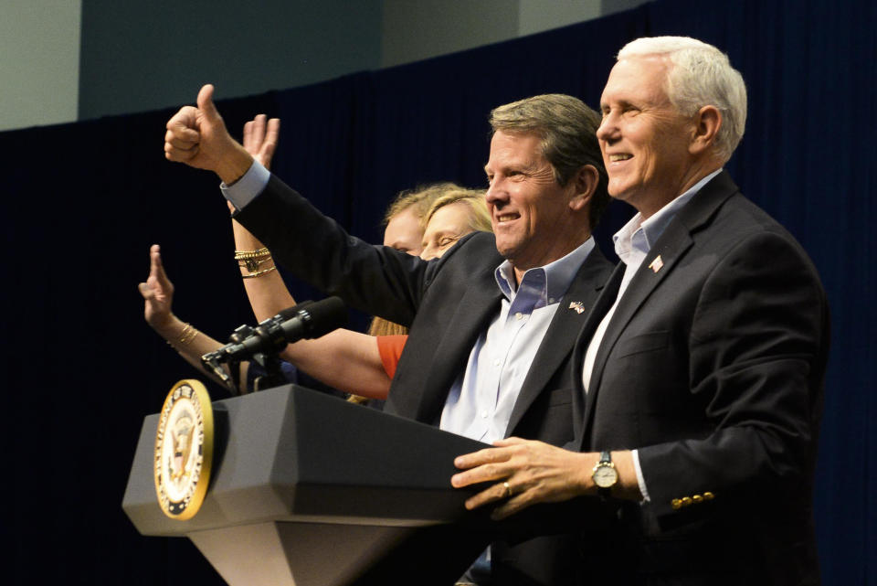 Georgia Republican gubernatorial candidate Brian Kemp, second left, and Vice President Mike Pence wave to the crowd at a Kemp rally held at the Savannah International Trade and Convention Center on Thursday, Nov. 1, 2018, in Savannah, Ga. Kemp's opponent is Democratic gubernatorial candidate Stacey Abrams. (Will Peebles/Savannah Morning News via AP)