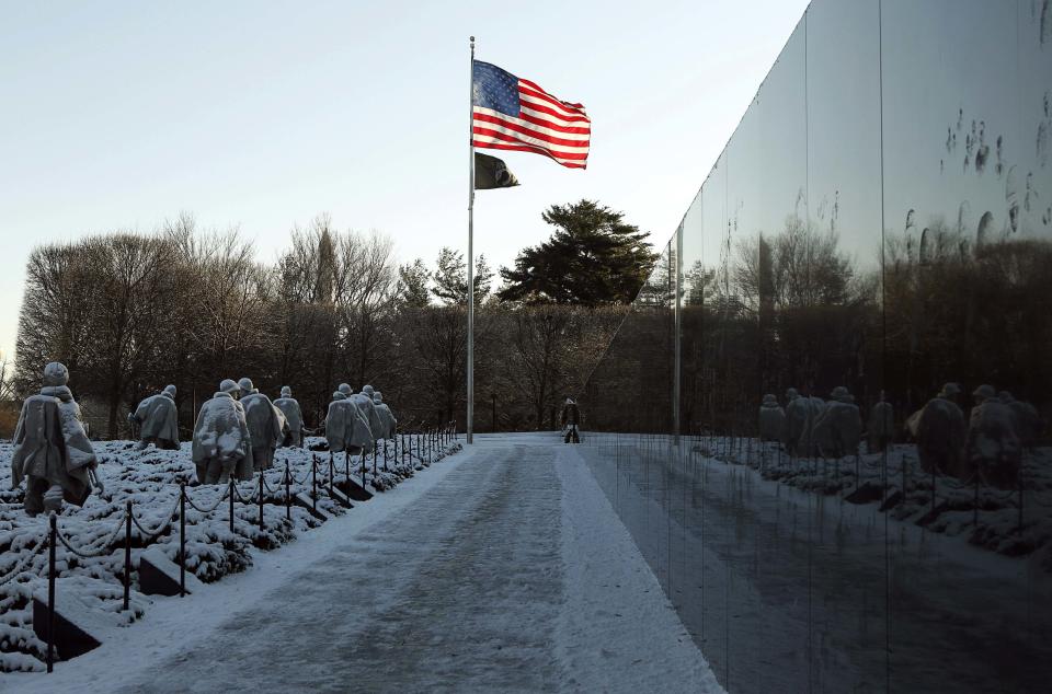 Korean War Veterans Memorial is reflected in black marble after a snow storm in Washington