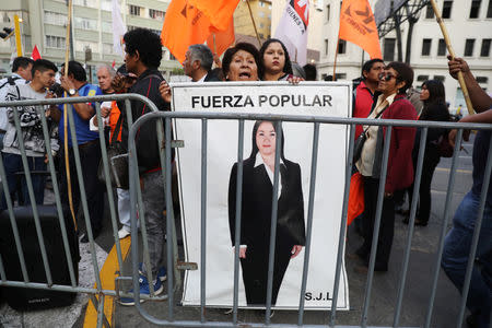 Supporters of opposition leader Keiko Fujimori hold a picture of her, as they wait outside a court where she is attending a hearing, in Lima, Peru October 31, 2018. REUTERS/Mariana Bazo