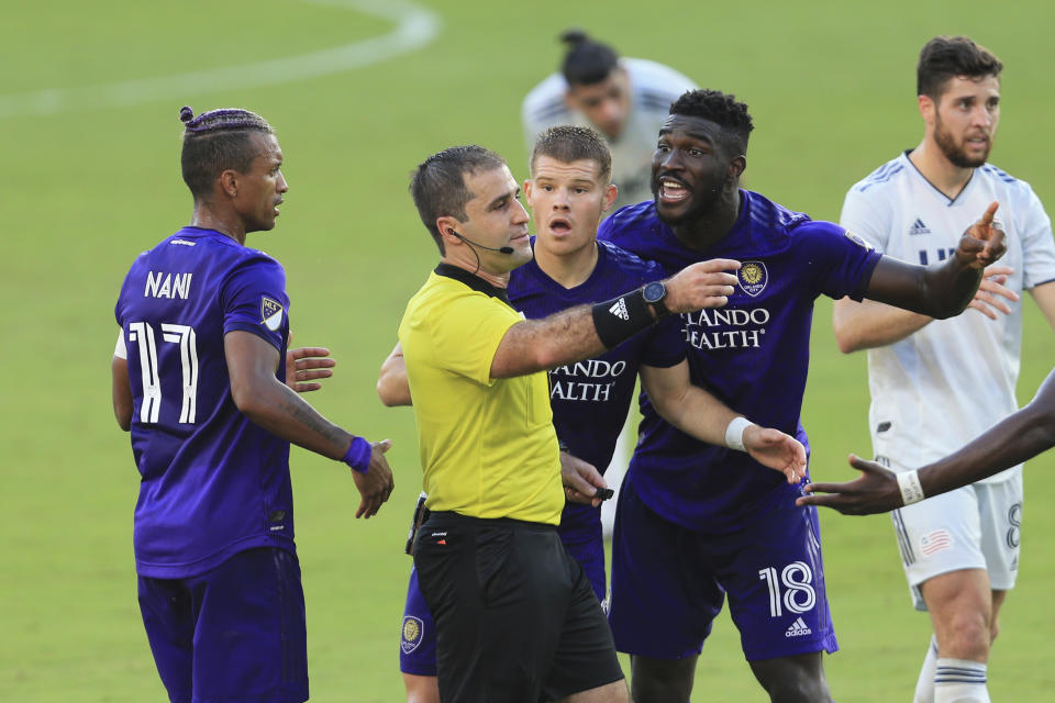 Orlando City forward Nani (17) and forward Chris Mueller (9) and forward Daryl Dike (18) argue with referee Alex Chilowicz during the second half of an MLS playoff soccer match against the New England Revolution, Sunday, Nov. 29, 2020, in Orlando, Fla. (AP Photo/Matt Stamey)