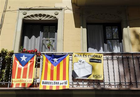 "Estelades" (Catalan separatist flags) seen hung beside a banner from a balcony in Barcelona, April 8, 2014. REUTERS/Albert Gea