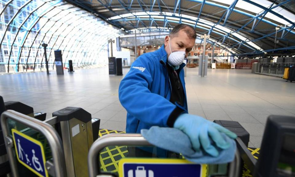 A Network Rail staff cleans ticket barriers at Waterloo station in London.