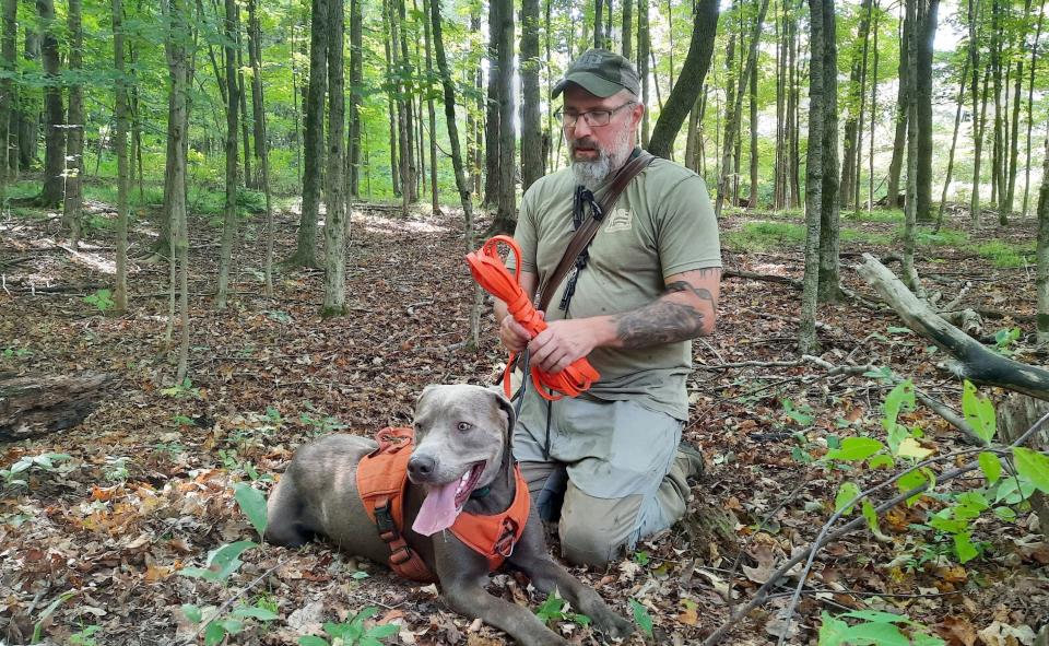 Michael Beck rolls up the 25-foot leash that was donated to him and his dog Dexter by someone who worked with  search and rescue dogs. “I feel honored to use it.”  The long leash is used when Dexter is trailing a wounded deer.