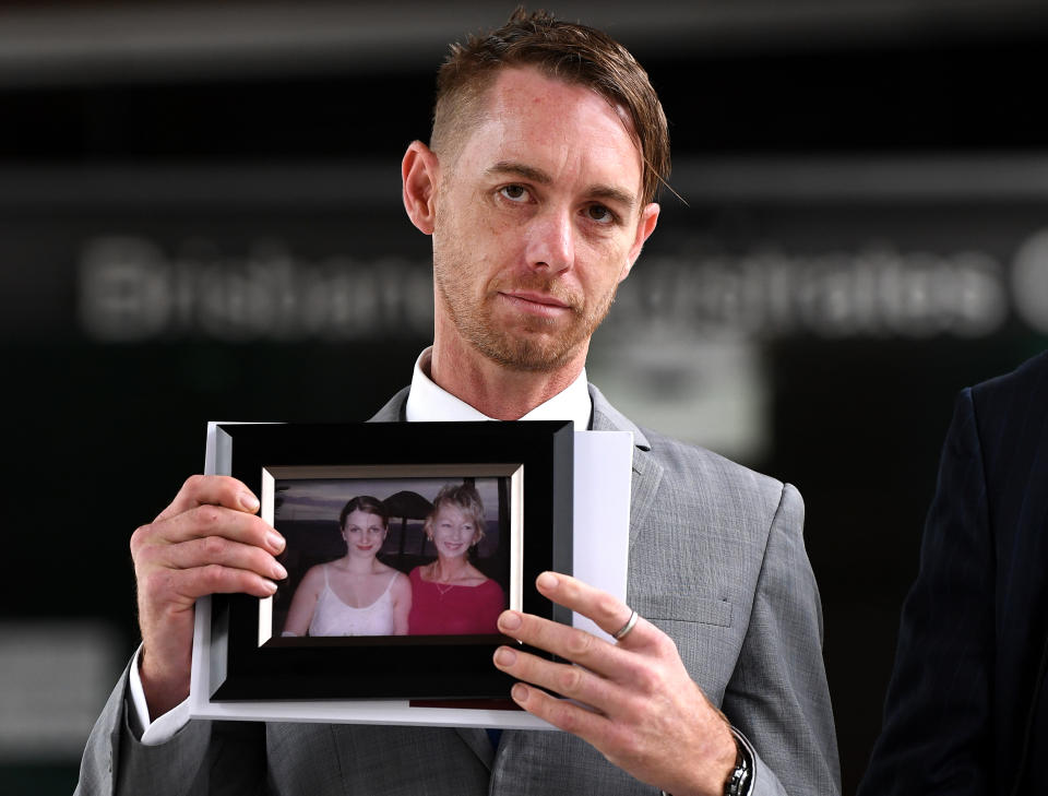 Michael Cooke, brother of Cindy Low, holds a picture of her in front of Brisbane's Magistrates Court. Source: AAP