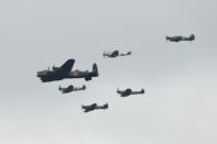 A World War II Lancaster bomber and Spitfire planes fly in formation to mark the centenary of the Royal Air Force, seen from the Wimbledon tennis championships