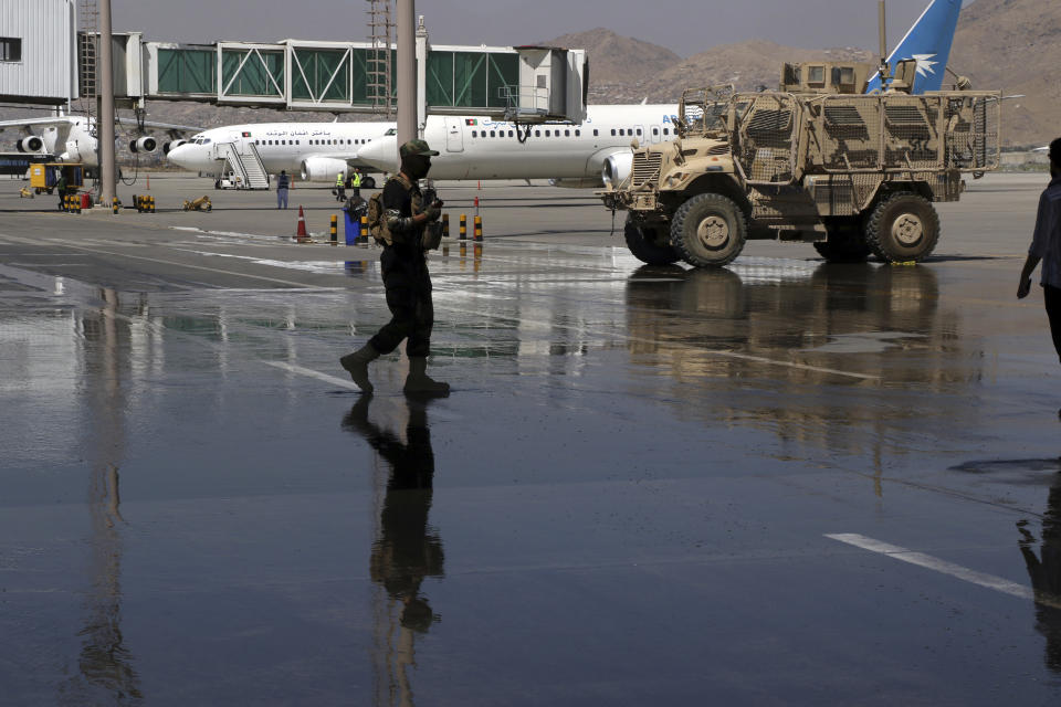 A Taliban soldier walks on the tarmac near parked planes at Hamid Karzai International Airport in Kabul, Afghanistan, Sunday, Sept. 5, 2021. Some domestic flights have resumed at Kabul's airport, with the state-run Ariana Afghan Airlines operating flights to three provinces. (AP Photo/Wali Sabawoon)