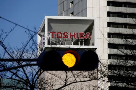 FILE PHOTO: The logo of Toshiba Corp is seen behind a traffic signal at its headquarters in Tokyo, Japan January 27, 2017. REUTERS/Toru Hanai/File Photo