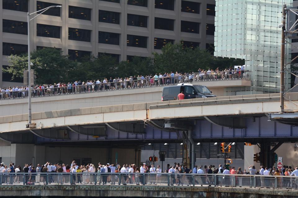 people crowded against the side of an expressway