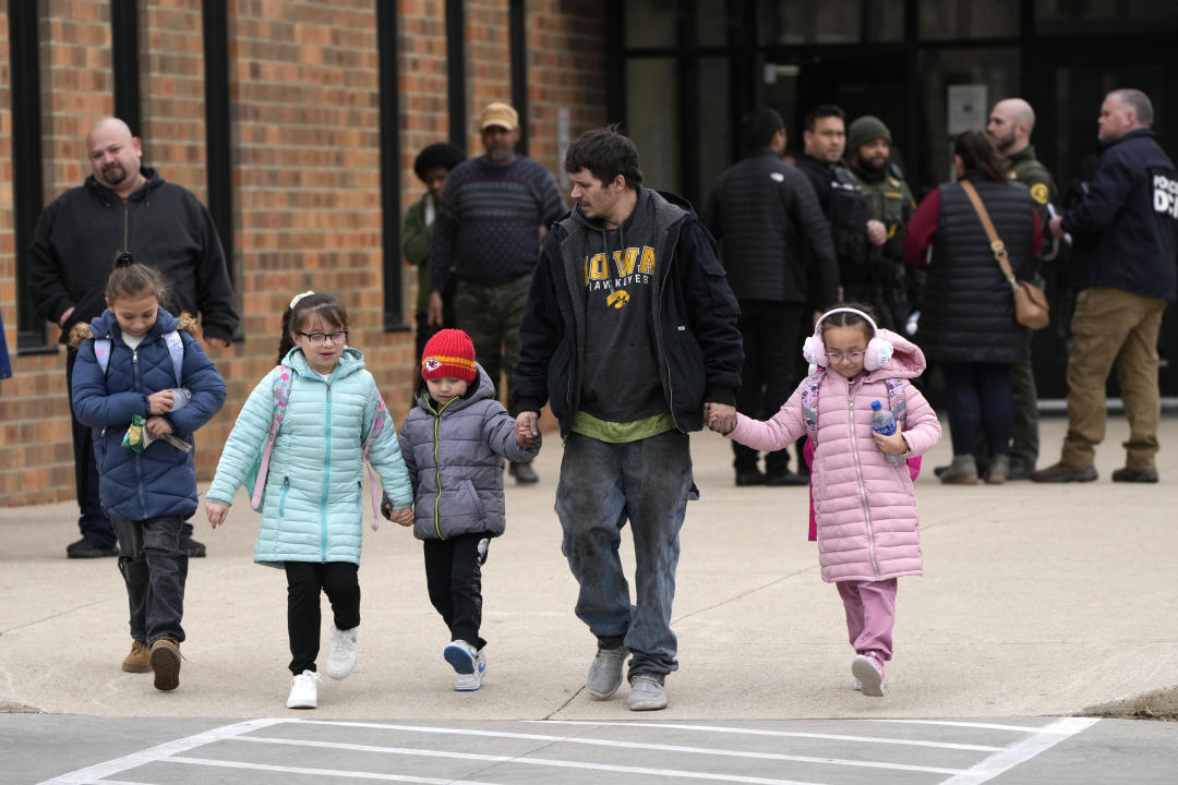 A man and children leave the McCreary Community Building after being reunited following a shooting at Perry High School, in Perry, Iowa, Thursday. (Charlie Neibergall/AP)