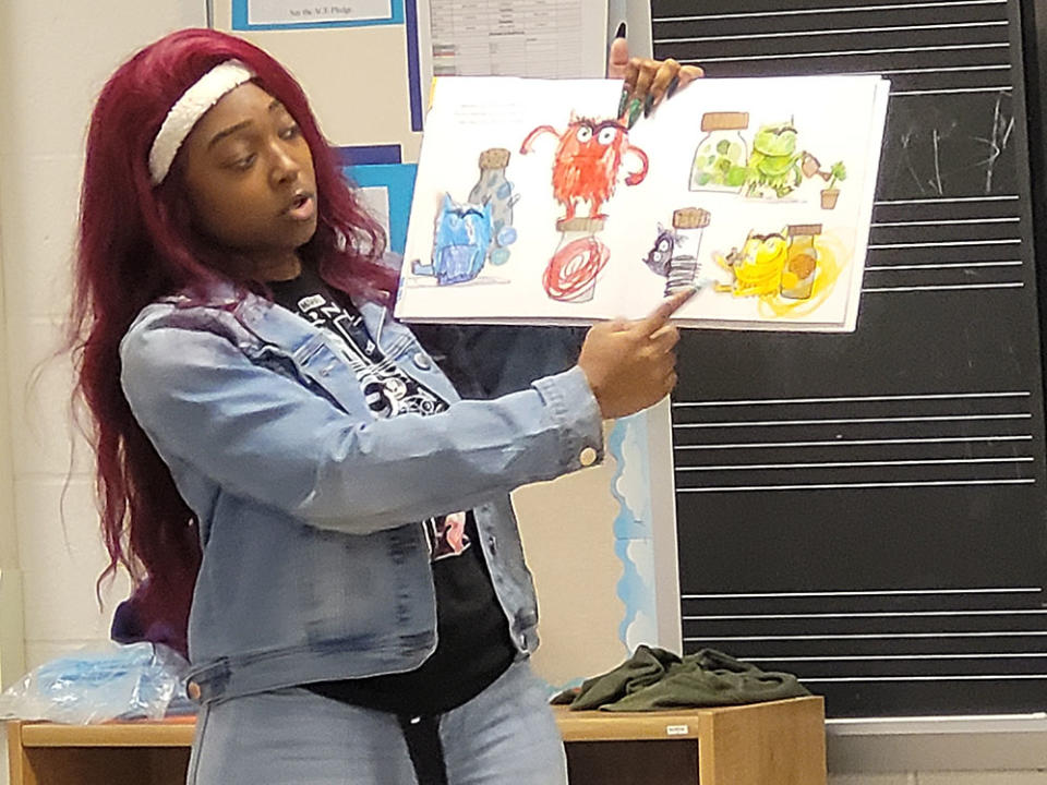 Kelli Price, a leader of the afterschool program at Cleveland’s Mary Martin Elementary School, reads to students. (Patrick O’Donnell)