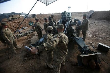 U.S. soldiers from the 2nd Brigade, 82nd Airborne Division clean the barrel of the artillery at a military base north of Mosul, Iraq, February 14, 2017. Picture taken February 14, 2017. REUTERS/Khalid al Mousily