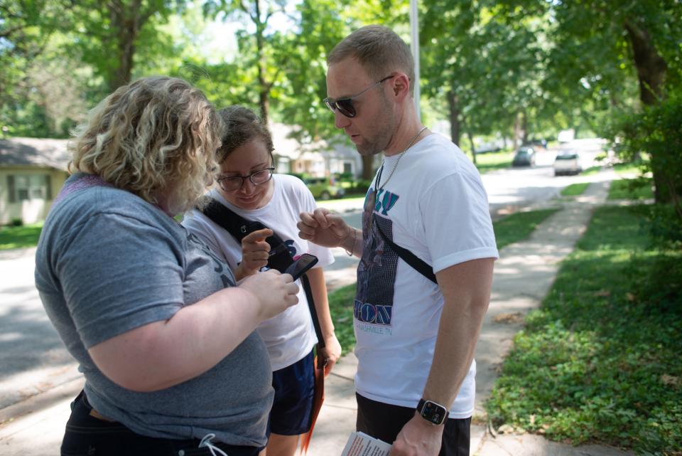 Traci Klein, from left, Mandy Culbertson and Paul Stark get directions to the next house on their route to canvassing with Kansans for Constitutional Freedom on July 25 in Overland Park.