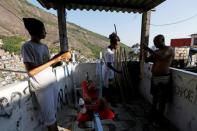 Manoel Pereira Costa (R), known as "Master Manel", prepares cabacas, to be used with the musical instrument berimbau, with two of his students at his home in the Rocinha favela in Rio de Janeiro, Brazil, July 24, 2016. REUTERS/Bruno Kelly