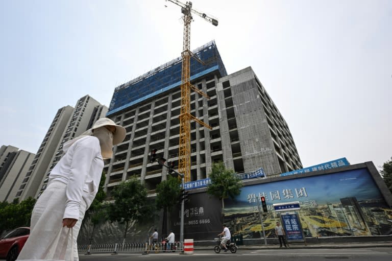 Une femme marche devant une résidence en construction le 5 juin 2024 à Tianjin, dans le nord de la Chine (Jade GAO)