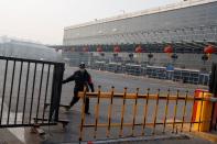 A security guard closes a gate at the Sihui Long Distance Bus Station in Beijing after the city has stoped inter-province buses services as the country is hit by an outbreak of the new coronavirus