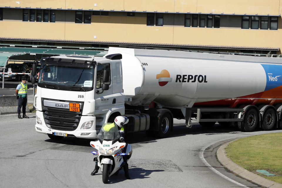 Police escorts a fuel truck leaving a fuel depot in Aveiras, outside Lisbon, Monday, Aug. 12, 2019. Portugal is rationing gas as a precaution after some 2,000 tanker truck drivers began an open-ended strike over pay on Monday. The government has set a limit of 25 liters (6.6 gallons) for customers at gas stations until further notice. (AP Photo/Armando Franca)