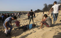 Protesters collapse after inhaling teargas during a protest on the beach at the border with Israel near Beit Lahiya, northern Gaza Strip, Monday, Sept. 17, 2018. (AP Photo/Adel Hana)