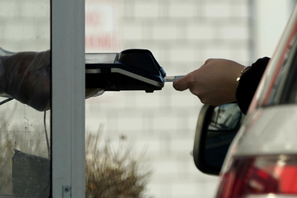 File - A card reader is used at a drive-thru restaurant in Mount Prospect, Ill., March 13, 2021. Noticeable pockets of Americans are quickly running up their credit card balances and increasing numbers are now falling behind on their debts. (AP Photo/Nam Y. Huh, File)