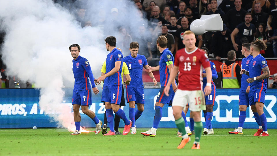 England players, pictured here being pelted with cups and allegedly racially abused. 