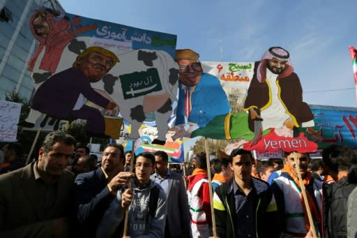 Iranian protesters hold placards mocking US President Donald Trump, Saudi King Salman and Crown Prince Mohammed bin Salman outside the former US embassy in Tehran on November 4, 2018