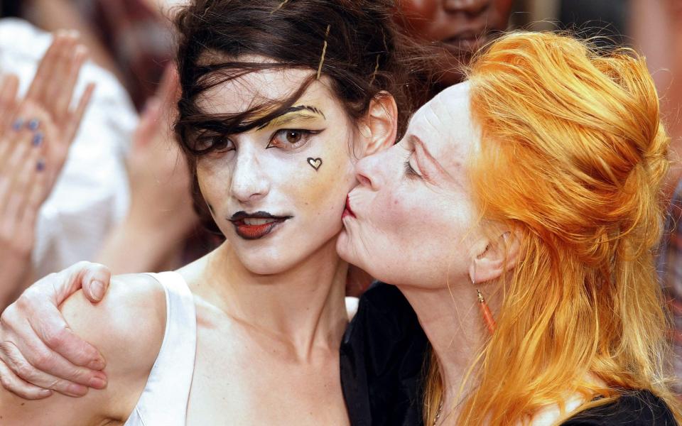 Vivienne Westwood (R) kisses the cheek of a model who presents her creations during the Spring/Summer 2011 ready-to-wear collection show in Paris - AFP