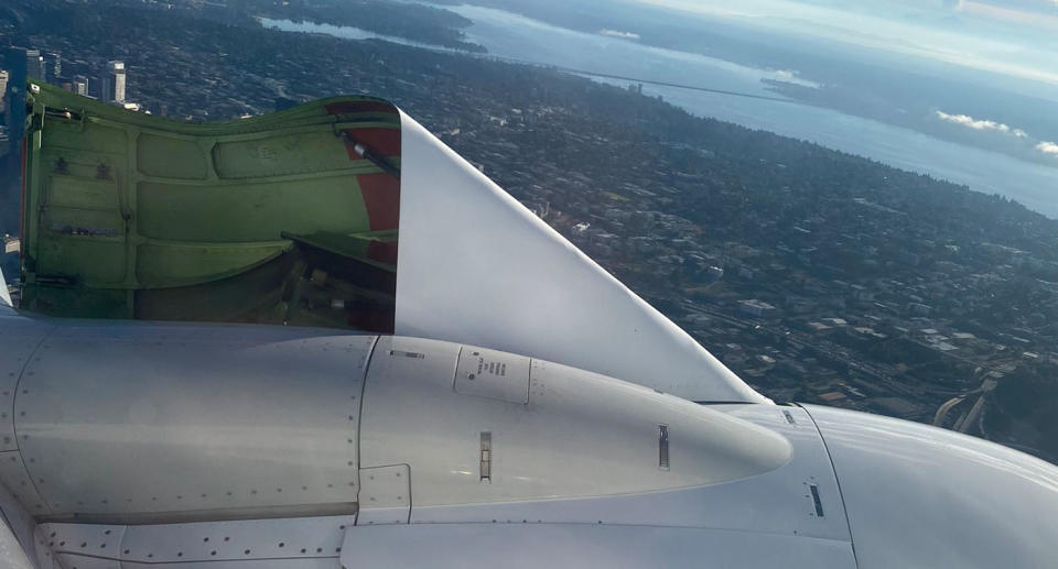 The cowling on the left engine of an Alaska Airlines plane flying off.