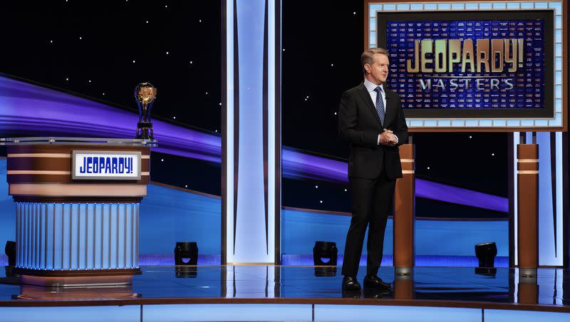 “Jeopardy!” host Ken Jennings stands next to the Trebek Trophy. 