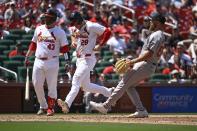 St. Louis Cardinals' Nolan Arenado (28) scores on a passed ball throw by Boston Red Sox relief pitcher Greg Weissert, right, as Cardinals' Pedro Pages, left, looks on in the seventh inning of a baseball game, Sunday, May 19, 2024, in St. Louis. (AP Photo/Joe Puetz)