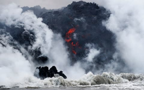 Lava flows into the ocean near Pahoa, Hawaii - Credit: AP