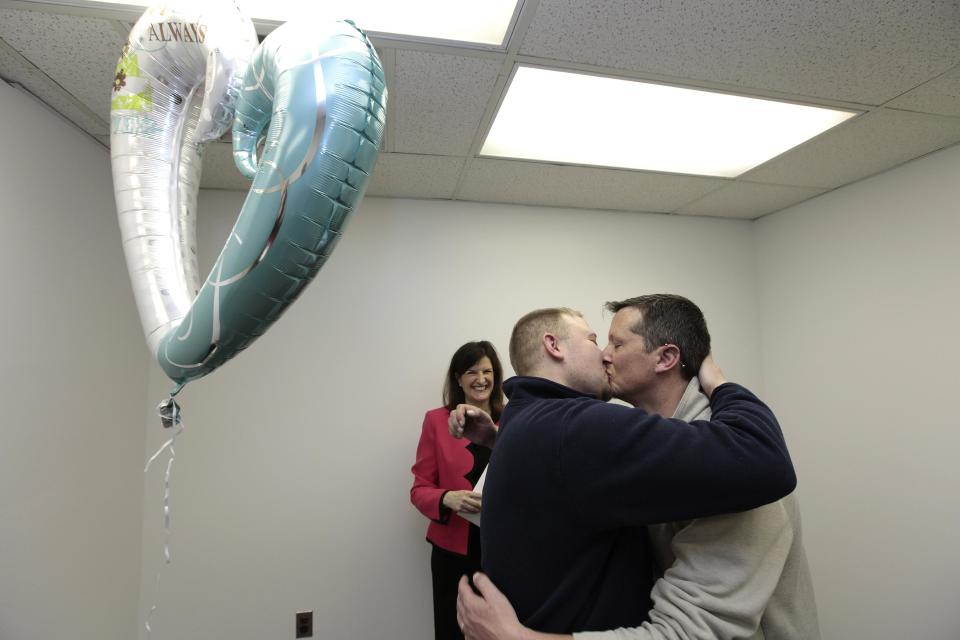 Justin Flowers, left, and Josh Redder kiss after being married by Oakland County Clerk Lisa Brown at the Oakland County Clerks office in Pontiac, Mich., Saturday, March 22, 2014. A federal judge has struck down Michigan's ban on gay marriage Friday the latest in a series of decisions overturning similar laws across the U.S. Some counties plan to issue marriage licenses to same-sex couples Saturday, less than 24 hours after a judge overturned Michigan's ban on gay marriage. (AP Photo/Paul Sancya)