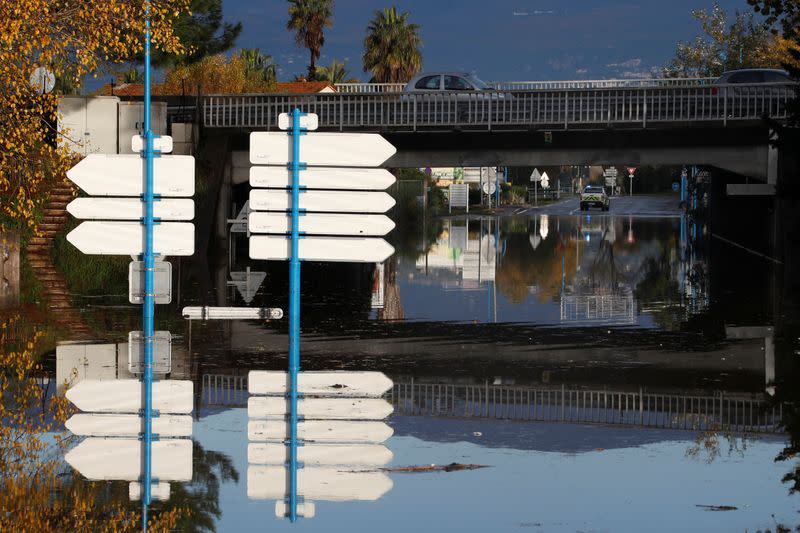 Road signs are seen in a flooded street after heavy rain fall in Mandelieu