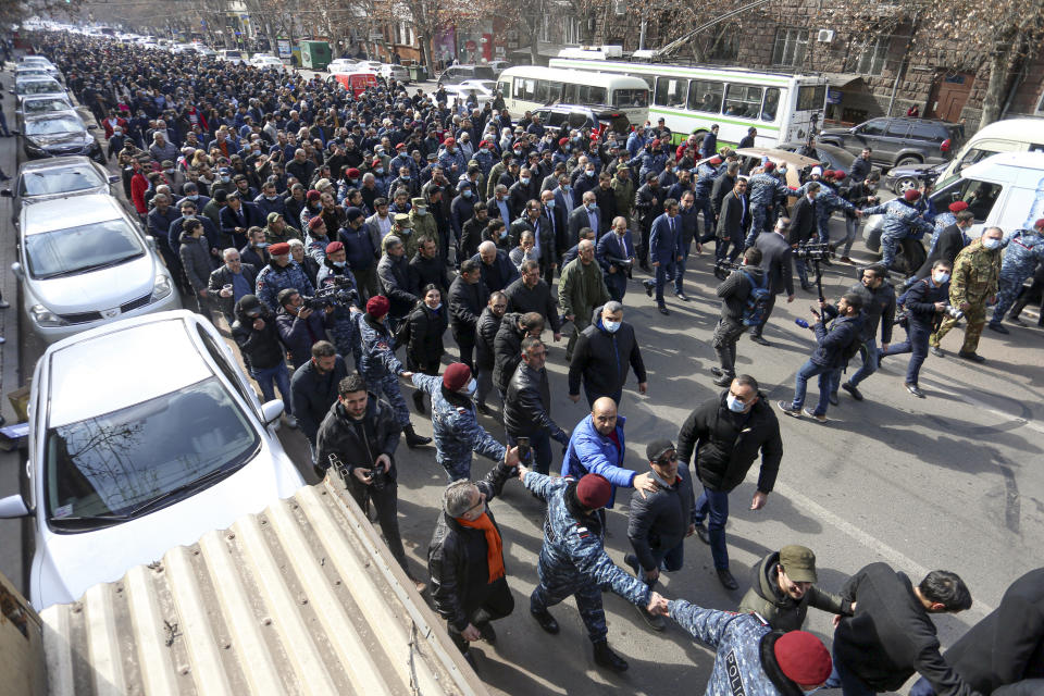 Armenian Prime Minister Nikol Pashinyan walks surrounded his supporters as he arrives at the main square in Yerevan, Armenia, Thursday, Feb. 25, 2021. Armenia's prime minister has spoken of an attempted military coup after facing the military's General Staff demand to step down. The developments come after months of protests sparked by the nation's defeat in the Nagorno-Karabakh conflict with Azerbaijan. (Stepan Poghosyan/PHOTOLURE via AP)