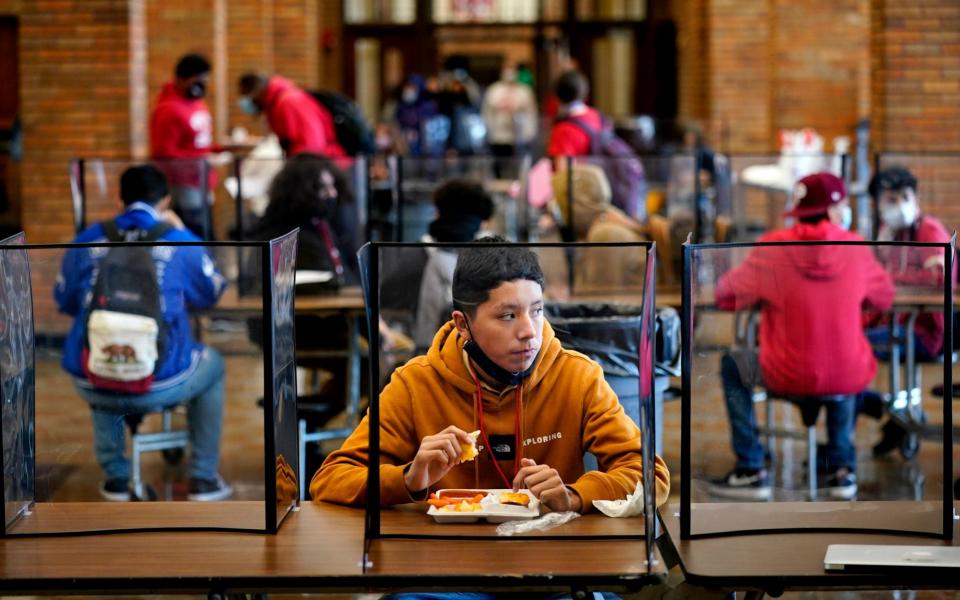 Students eats lunch separated from classmates by plastic dividers on the first day of in-person learning Wednesday - AP Photo/Charlie Riedel