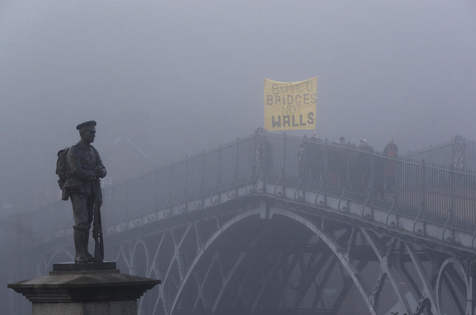 Demonstrators hold a banner on Ironbridge in protest of Donald Trump