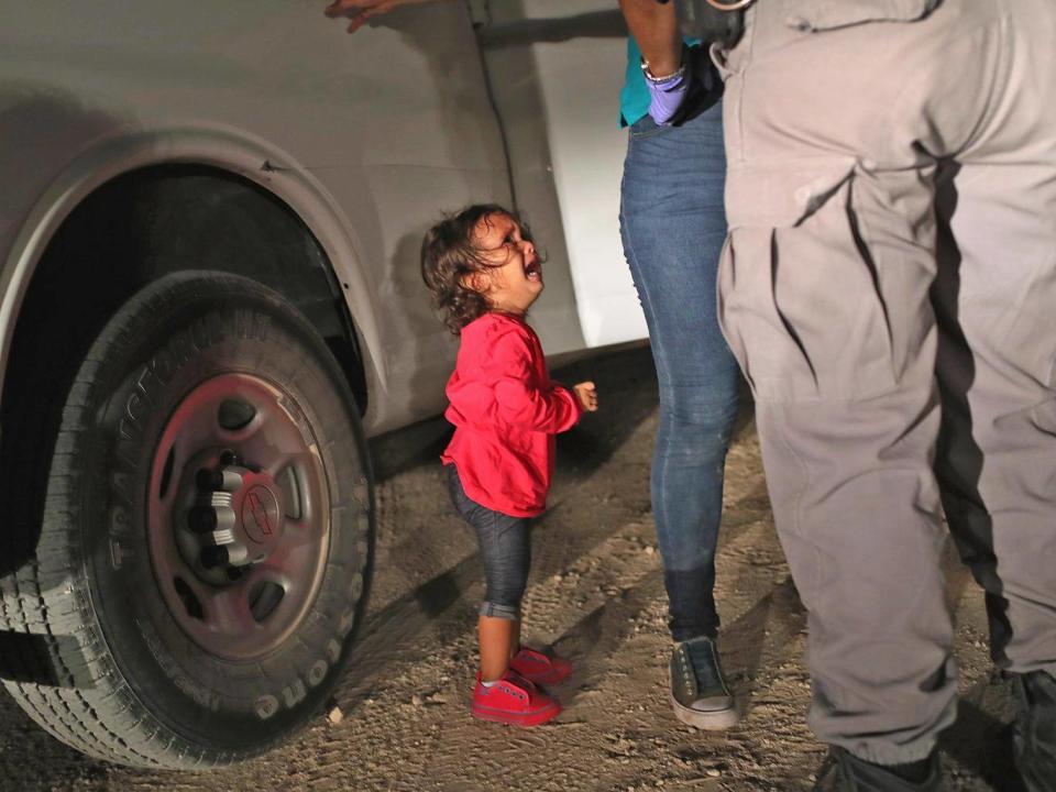 A two-year-old Honduran asylum seeker cries as her mother is searched and detained near the US-Mexico border on June 12, 2018 in McAllen, Texas ( (Photo by John Moore/Getty Images))